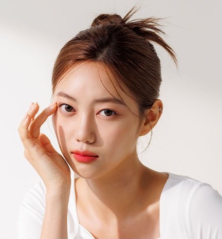以指尖輕點眼周的女性模特兒上半身