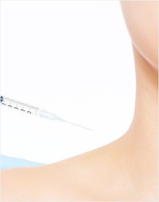 女性の肩と腕のラインを背景に、細い注射針が向かうボディボトックスの画像