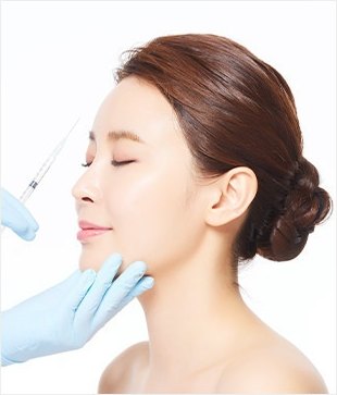 目を閉じた女性の横顔に、青い手袋をした両手が注射器を当てているフルフェイスボトックスの画像