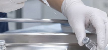 라텍스 장갑을 낀 의료진의 손이 스테인리스 트레이 위 바이알을 다루는 장면